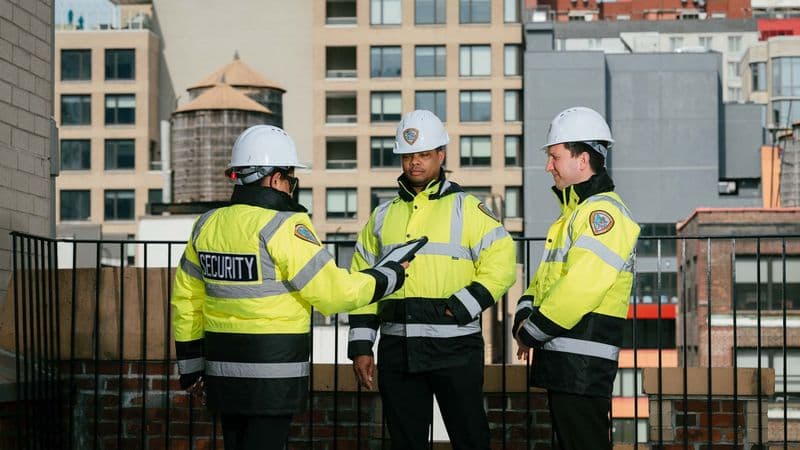 Image of far shot of 3 security guards on a roof.