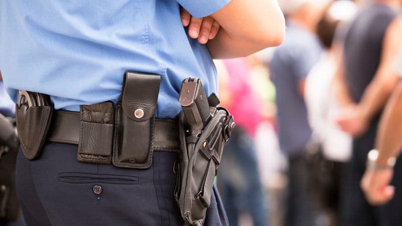 Image of an armed security officer guarding an executive at an event.