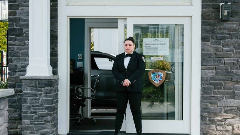 Image of a Security USA® gated community security guard standing by entrance guard house.