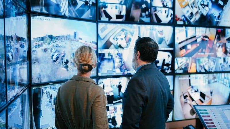 Image of Security USA® account manager and specialist in central monitoring control center with surveillance displays.