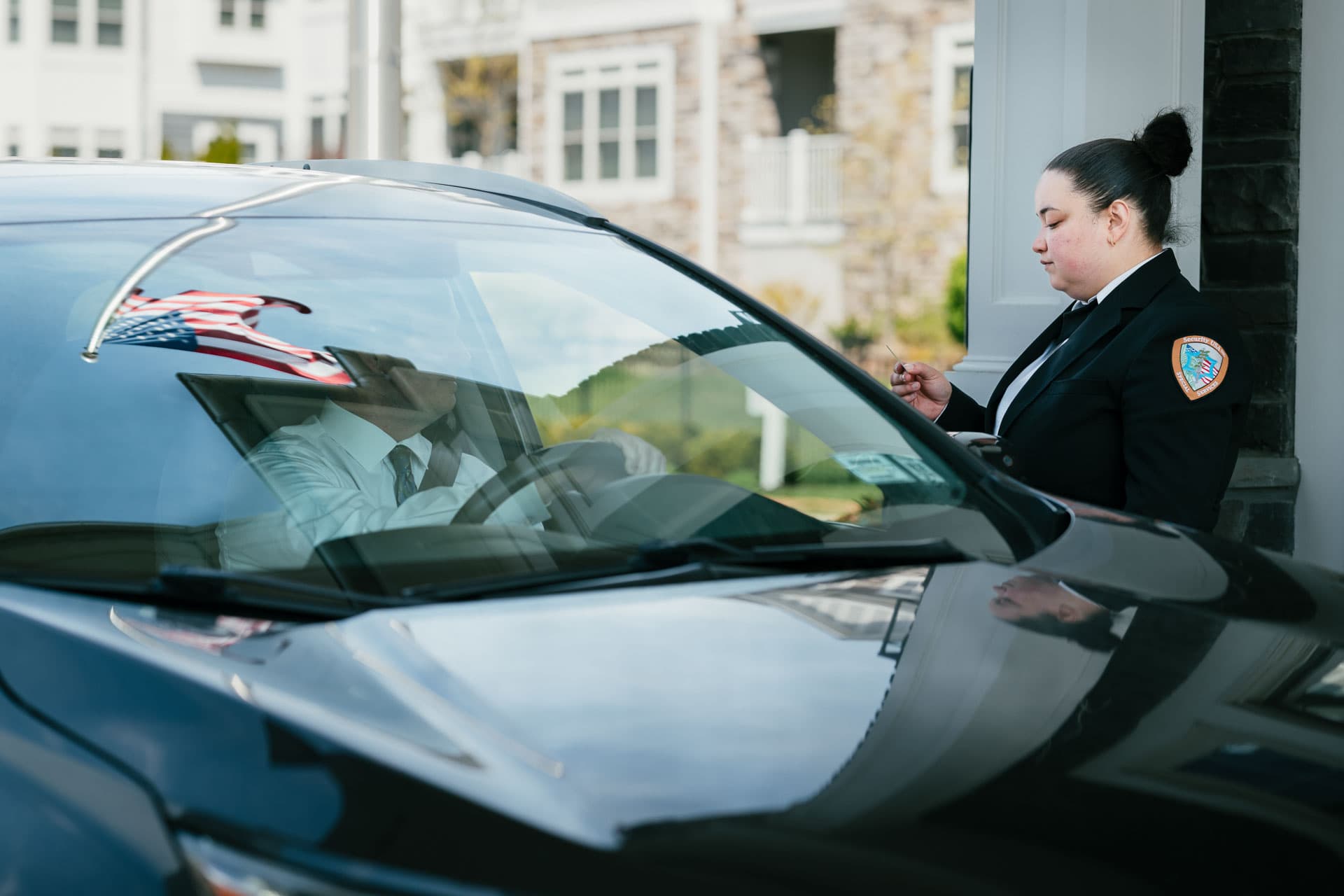 Image of a Security USA® front gate security guard checking a guests ID.