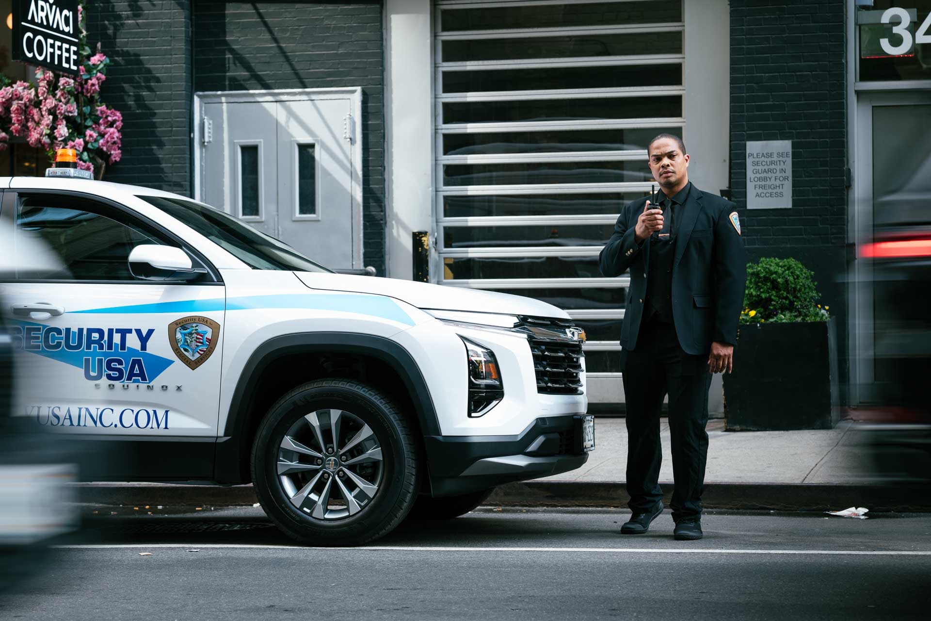 Security guard with radio near a patrol vehicle
