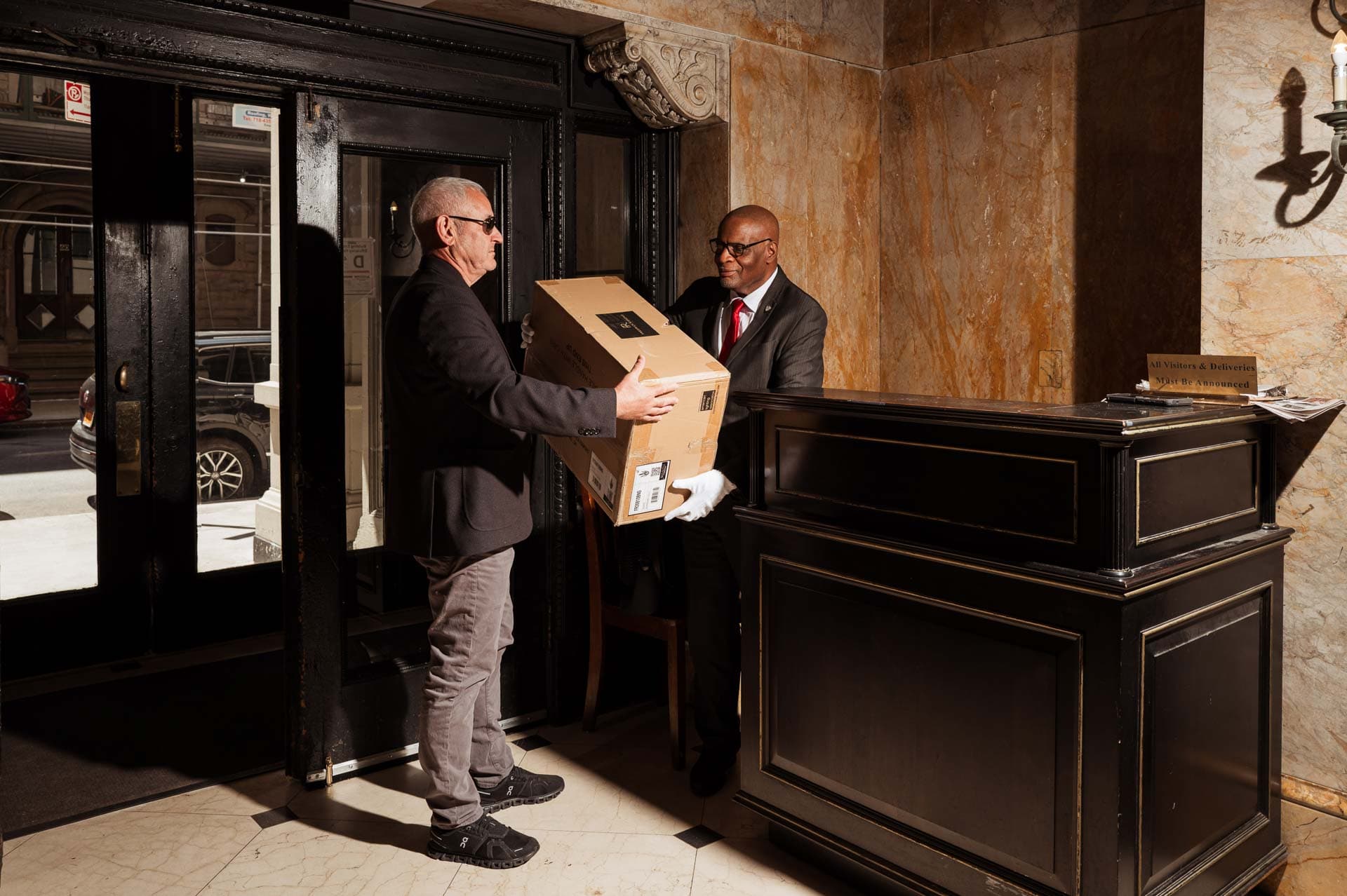 Image of a Security USA® white glove concierge giving a package to a resident in a residential building.