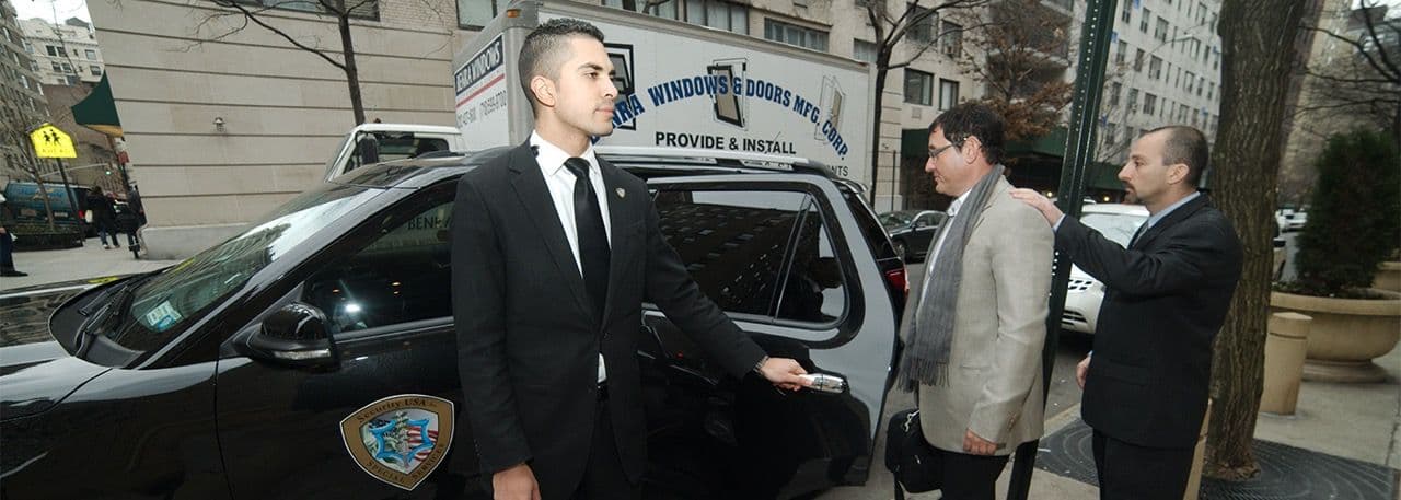 Image of a Security USA® armed executive protection agent holding a car door for an executive.