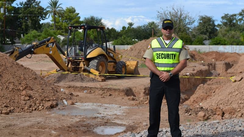 Image of a security officer monitoring access at active construction site.