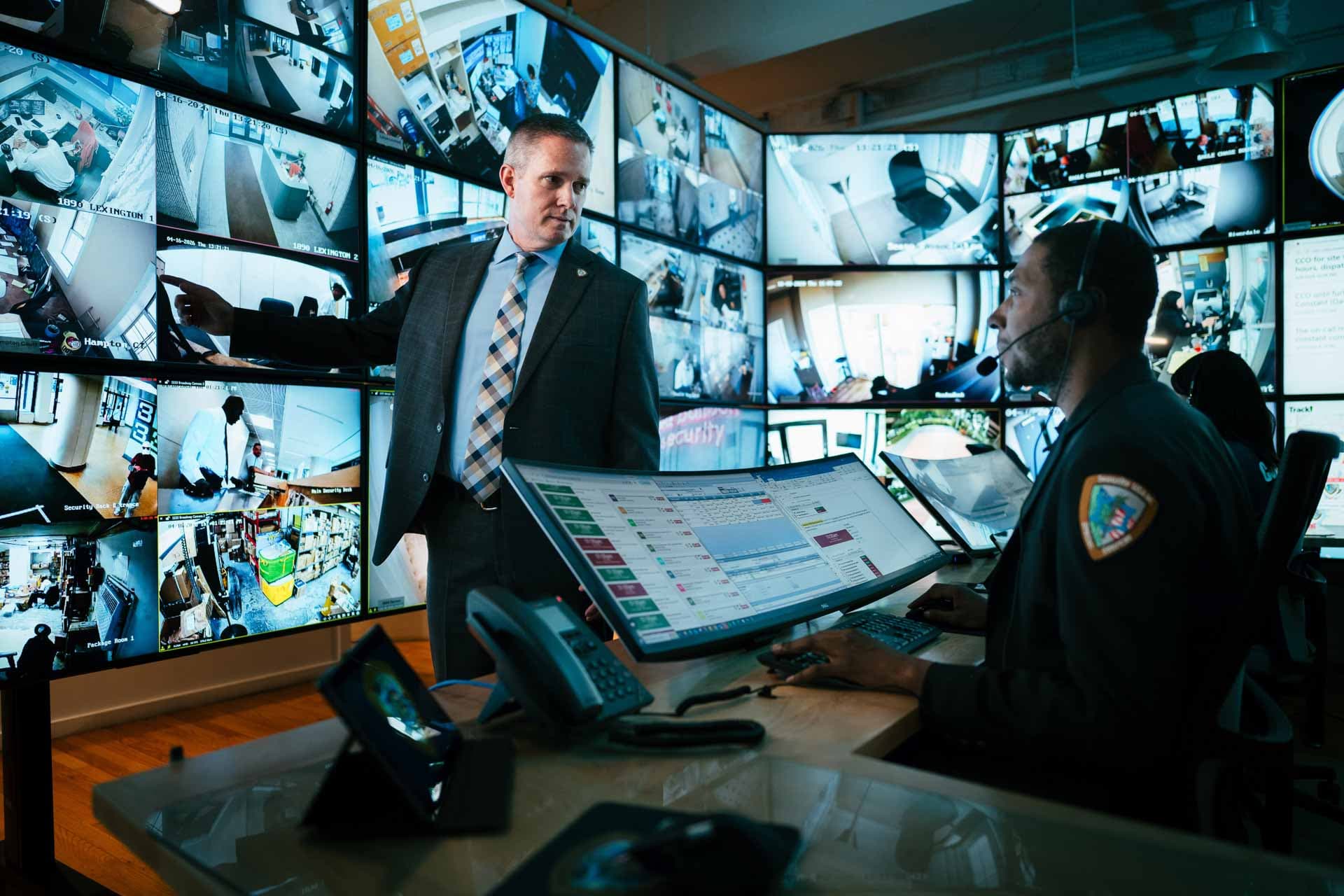 Image of security supervisor reviewing incident reports and live monitoring feeds with security personnel.
