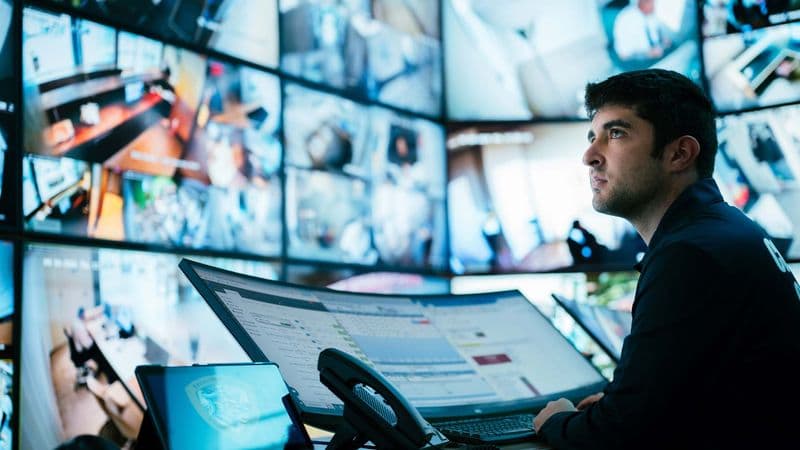 Image of data analyst monitoring in command center.