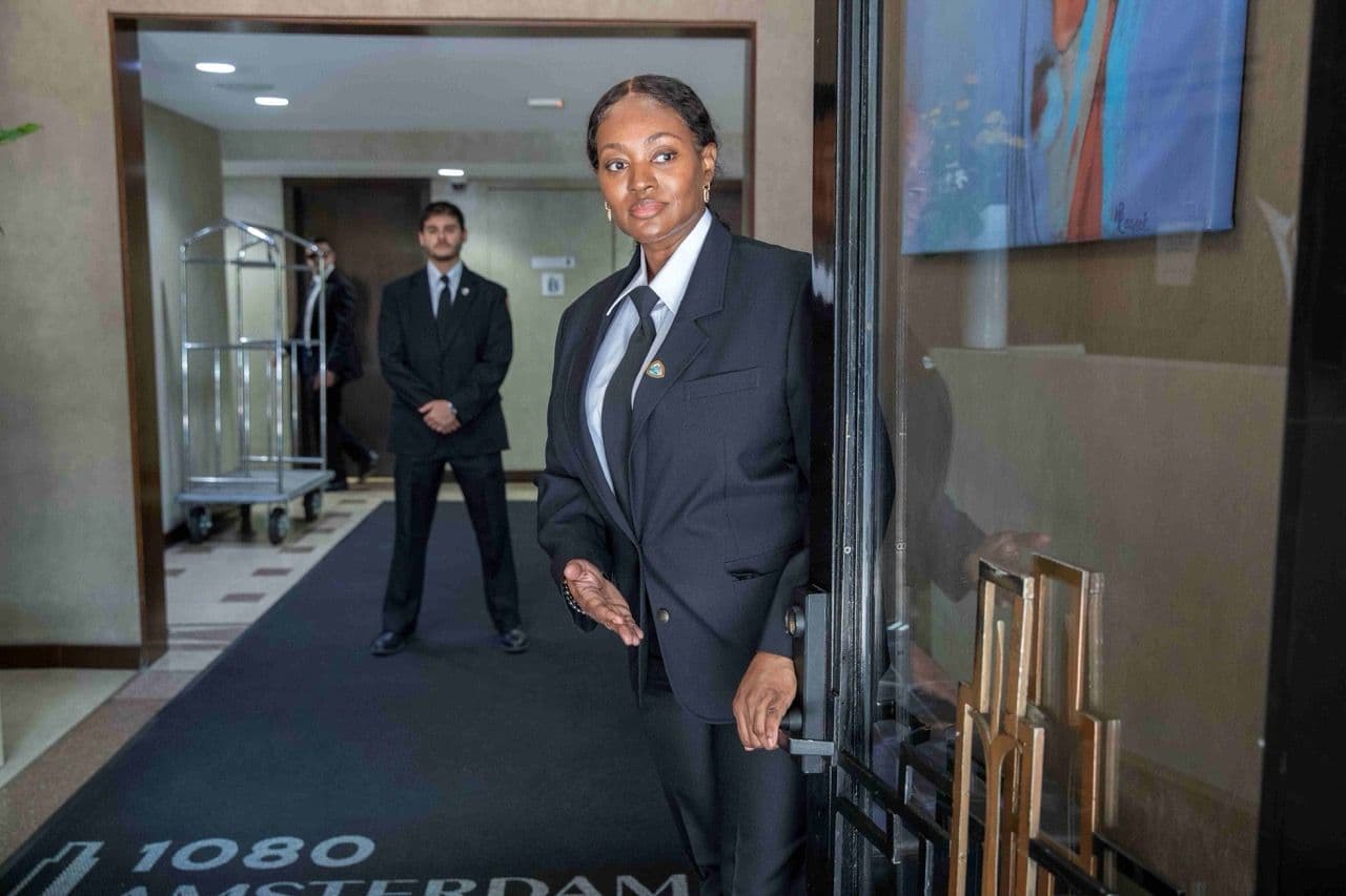 Image of a Security USA® doorman and concierge standing at the front entrance of a residential building.