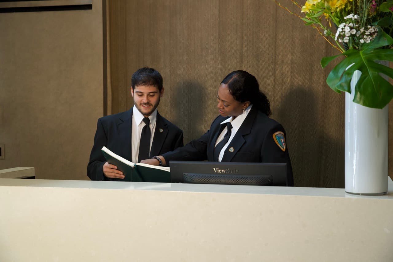 Security guard standing behind a reception counter
