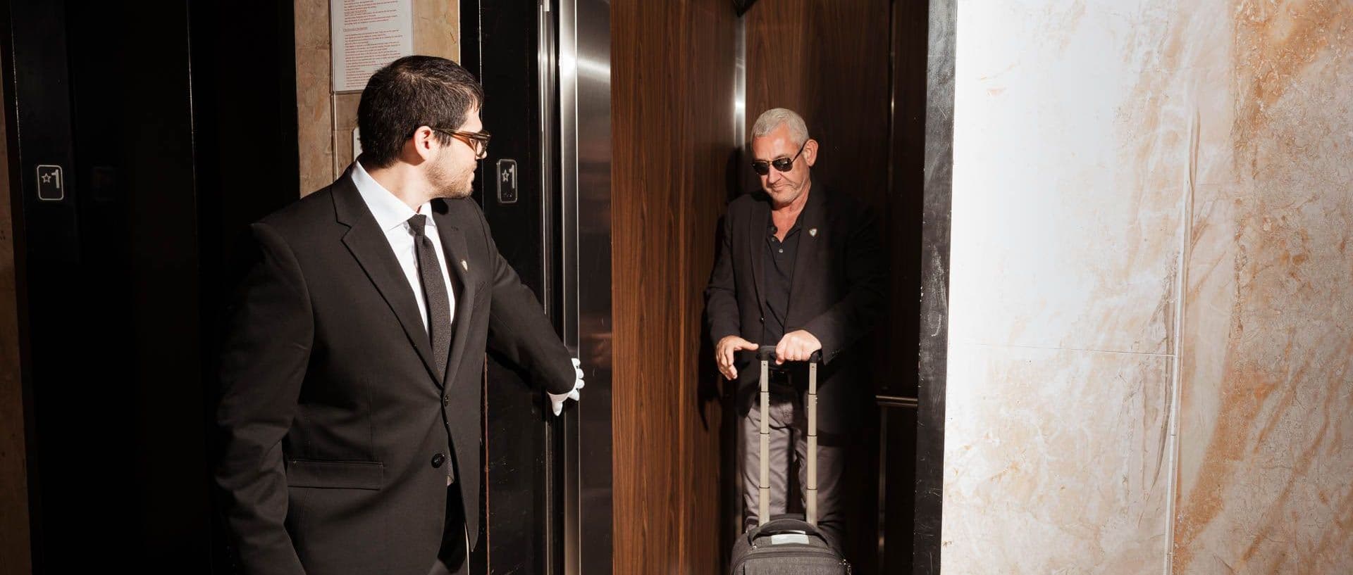 Image of a Security USA® white glove attendant assisting resident into elevator.