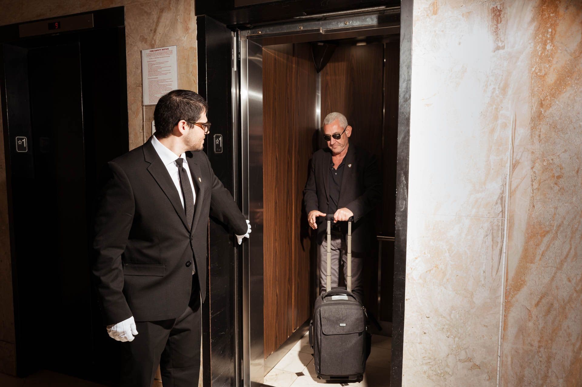 Image of a Security USA® white glove attendant assisting resident into elevator.