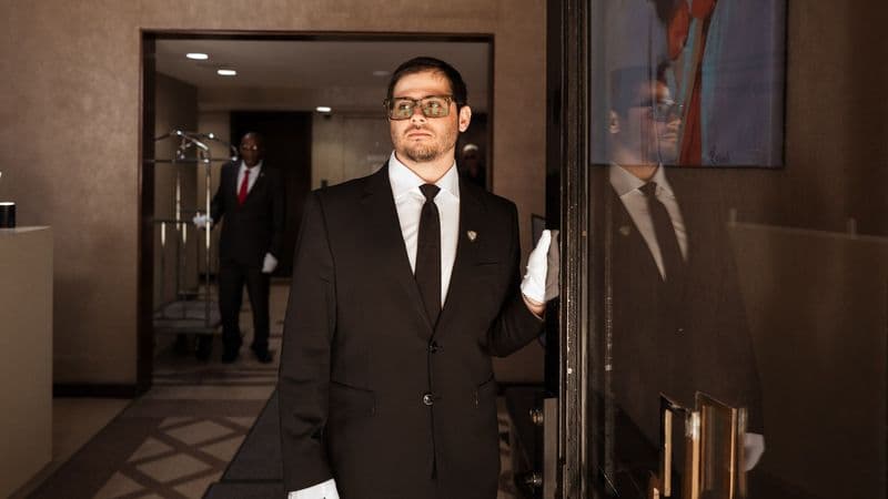 Image of a Security USA® white glove attendant opening a residential buildings front door.