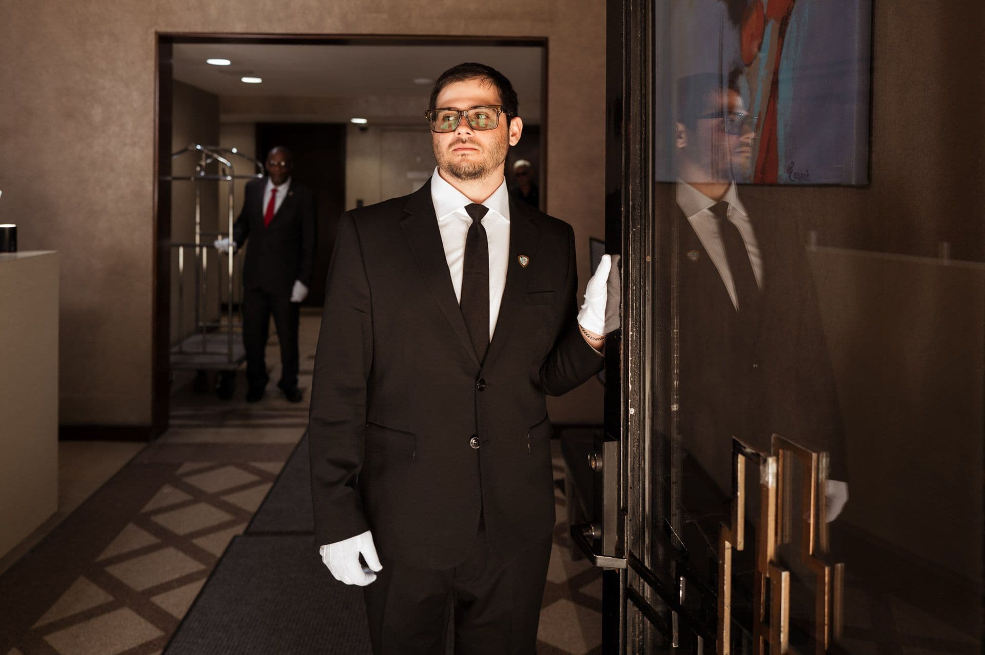 Image of a Security USA® white glove attendant opening a residential buildings front door.