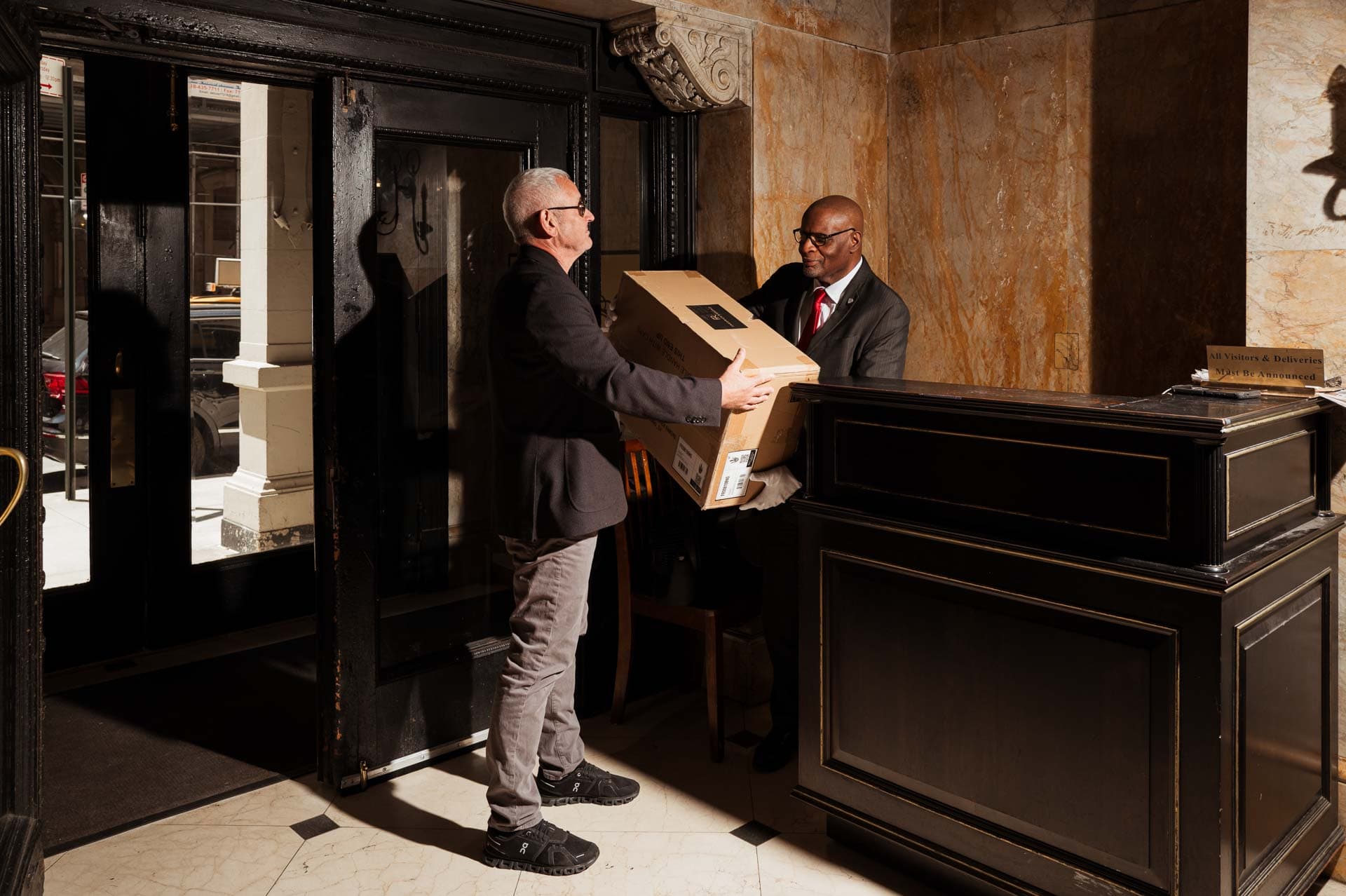 Image of a Security USA®'s concierge assisting a resident with packages.